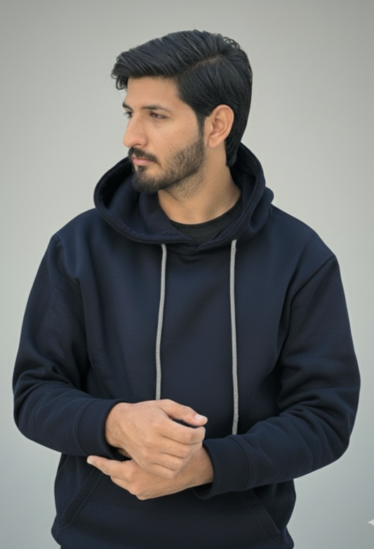 Man wearing a navy blue hoodie against a gray background